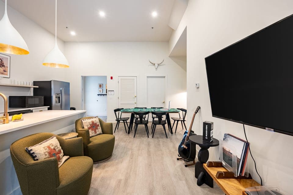Cozy living room with plush seating, TV, and guitar.