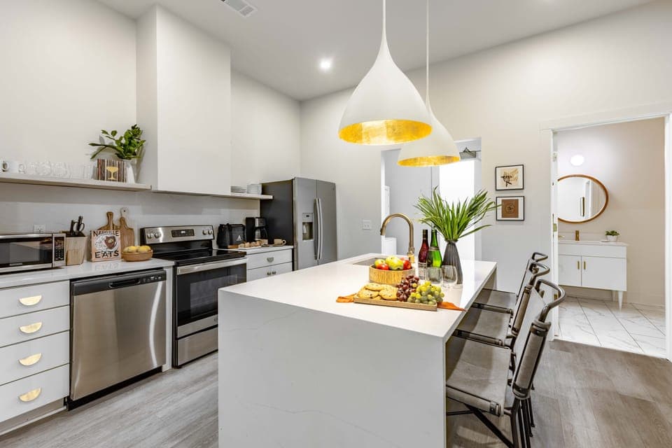 Sleek kitchen features an island with barstool seating.