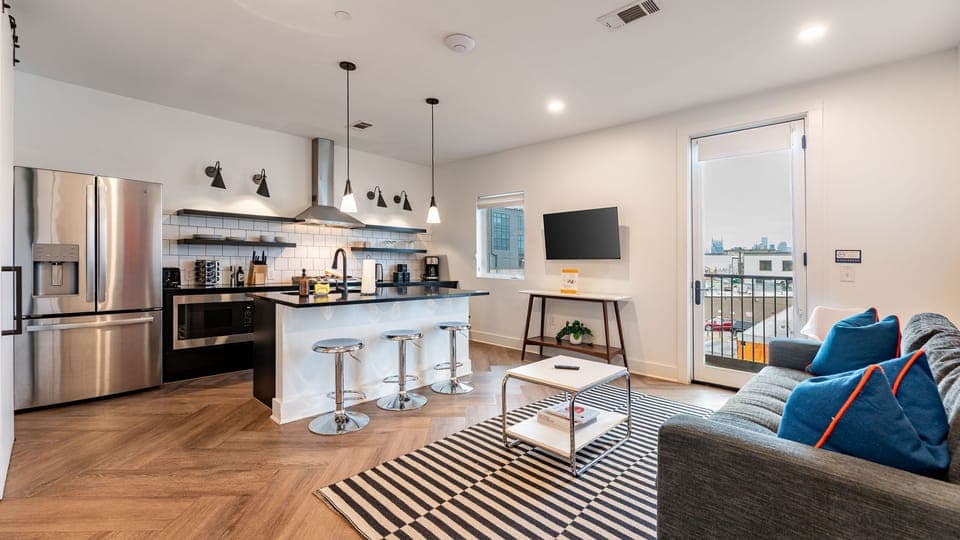 Sleek open-concept living with a modern kitchen and city views.