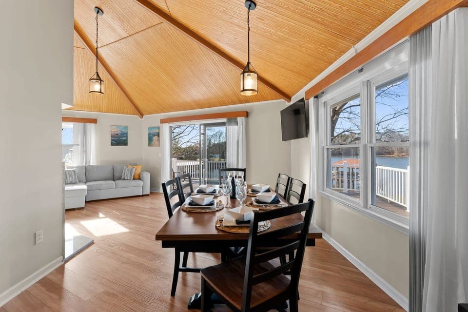 Dining area with table seating 6 and living room couch with chaise lounge and TV.