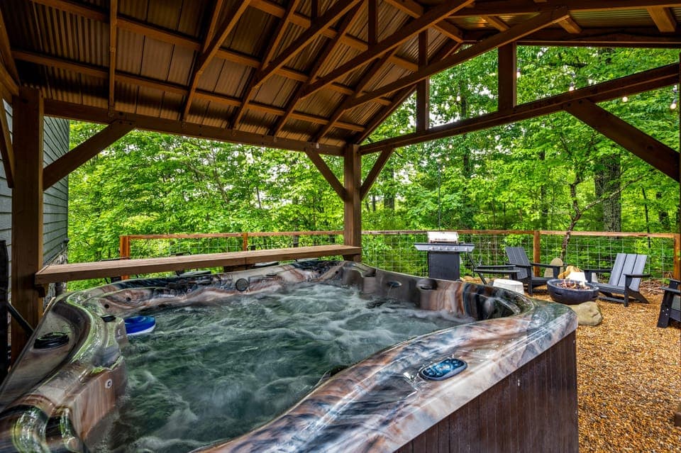 Shared spacious covered 7-person hot tub area surrounded by nature.