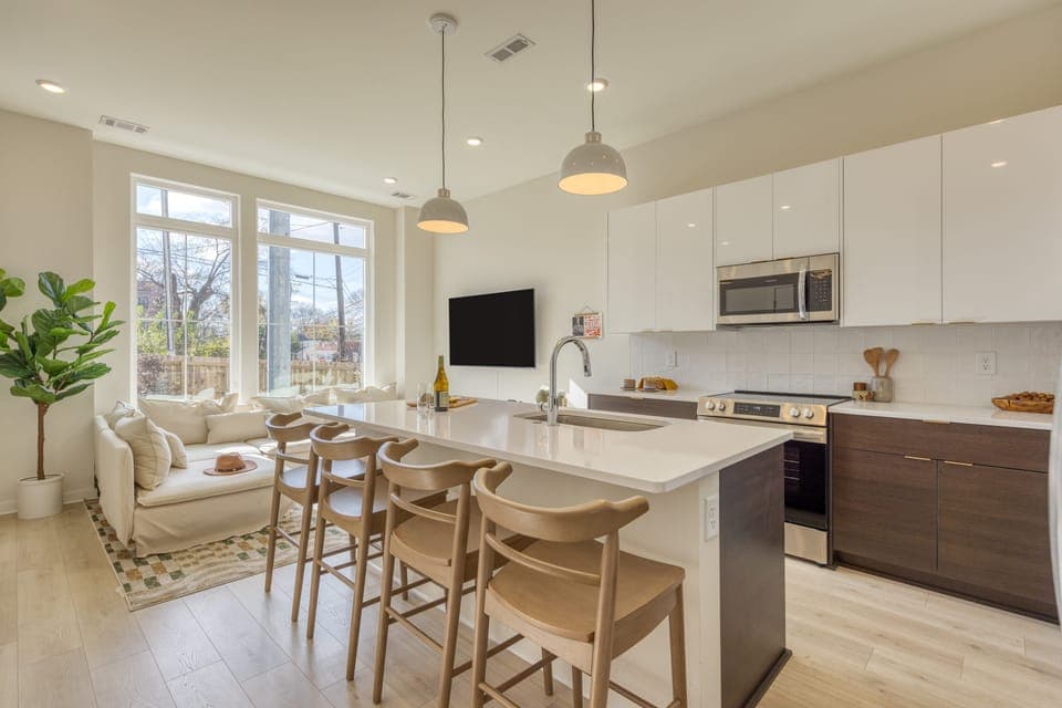 Kitchen features an island with barstool seating. (Lischey)
