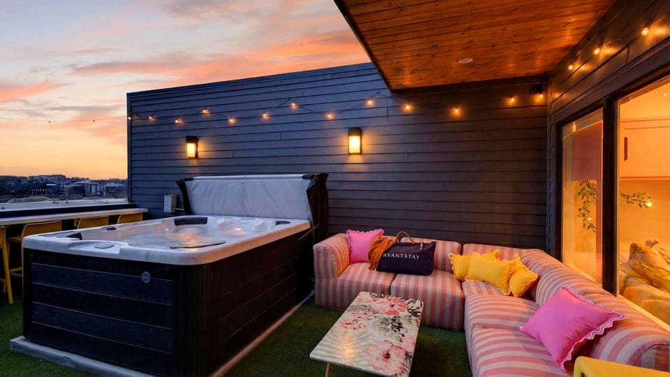 Rooftop hot tub with skyline views, string lights, and sunset vibes. (Girls Night Out)