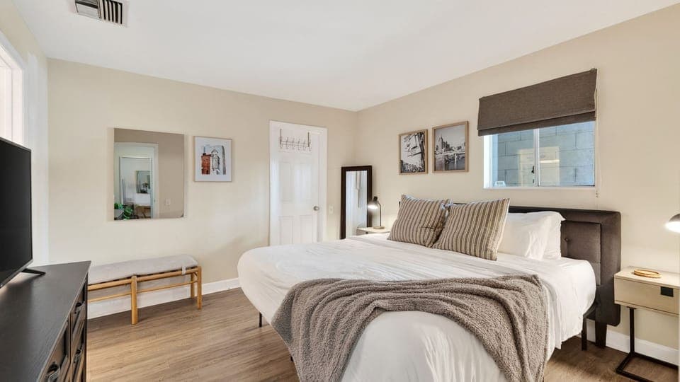 Tranquil master suite with a plush king-sized bed and hardwood floors.