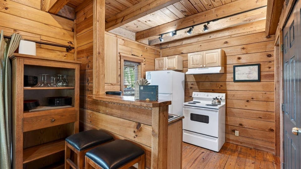 A charming, cabin-style kitchen with rustic wood finishes and a breakfast bar—perfect for easy mornings and casual meals. (Elijah's Cabin)