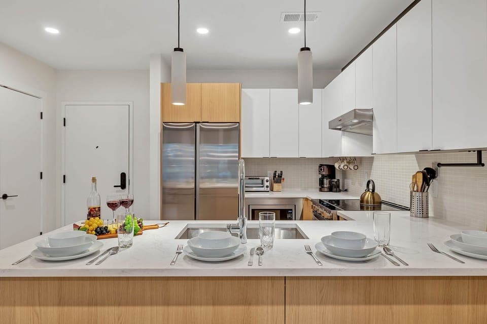 Fully equipped modern kitchen stocked with all culinary essentials and featuring brand new stainless steel appliances with bar seating.