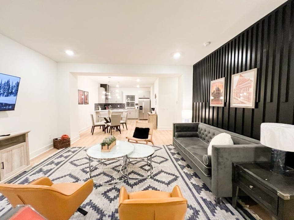 OPEN FLOOR PLAN LIVING ROOM – Step into this stylish, open-concept living and dining area, complete with modern furnishings, a plush sofa, and a 52" flat-screen TV,  ideal for a comfortable and inviting stay in Nashville!