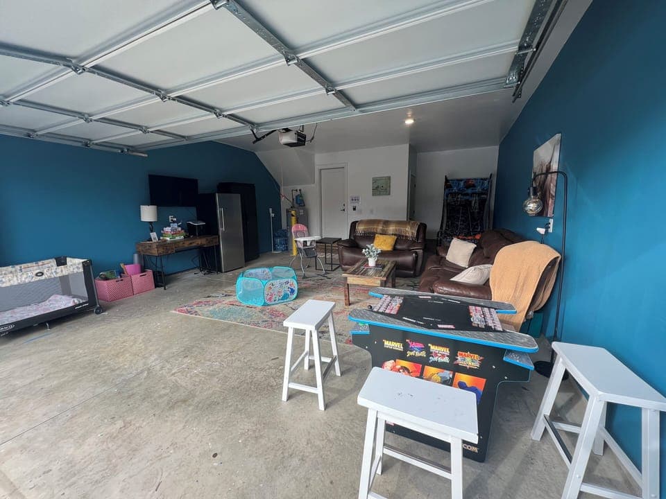 GAME ROOM - Step into our ultimate garage arcade! With a cocktail table game machine, TV, refrigerator, and comfy sofa, your stay promises non-stop fun and relaxation. Welcome to your entertainment paradise