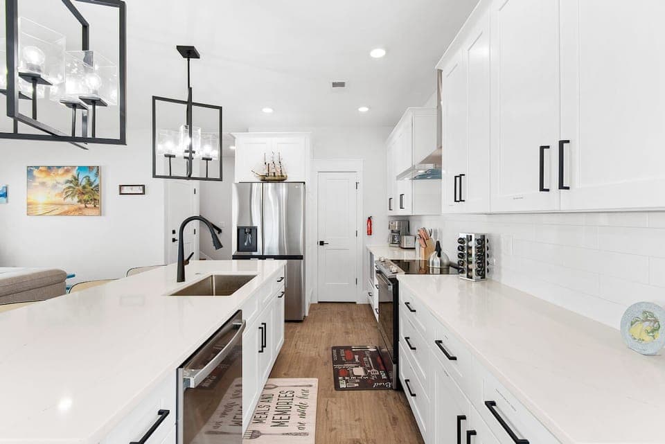 Step into your bright, modern kitchen featuring crisp white cabinetry, sleek quartz counters, and stainless appliances perfect for cooking memorable meals.