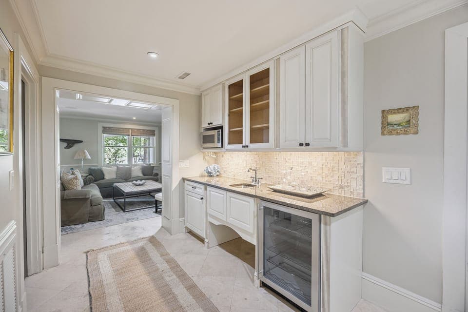 Wet bar area with microwave, sink, and wine cooler.