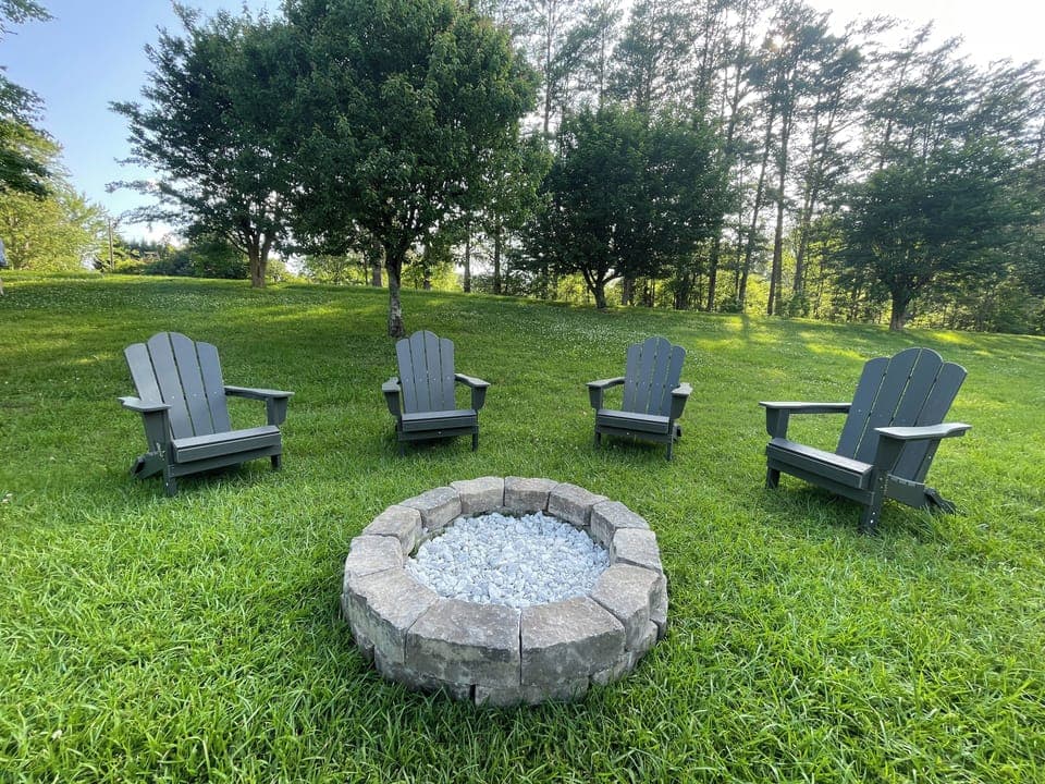 Outdoor fire pit with Adirondack chairs.