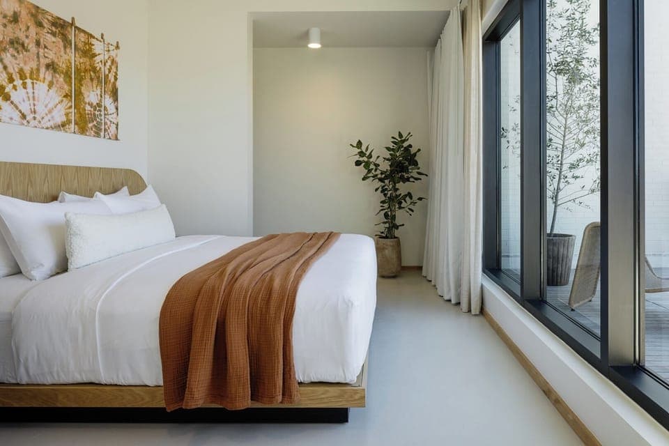 Wake up refreshed beside floor-to-ceiling windows and calm design.
