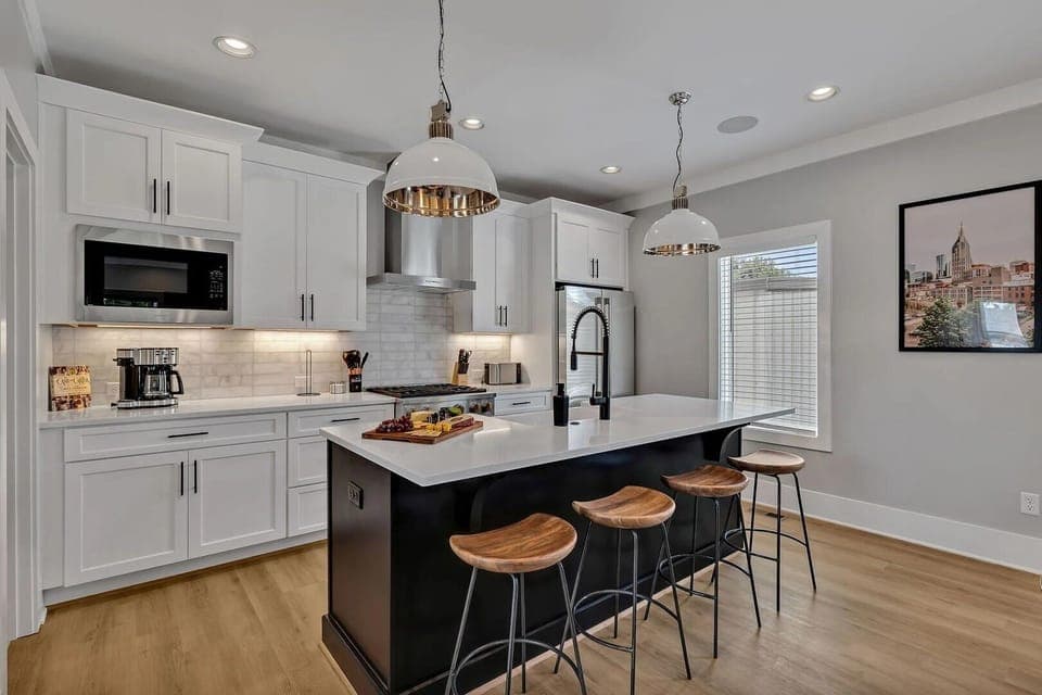 (Unit 1) 2nd Floor: Fully equipped kitchen, complete with all essential culinary tools, boasts stainless-steel appliances and a spacious island with ample counter space and bar seating.