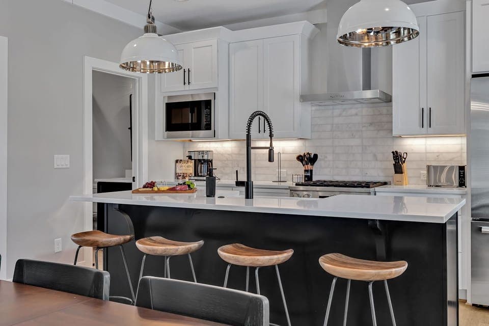 Unit 1 - 2nd Floor: Fully equipped kitchen, complete with all essential culinary tools, boasts stainless-steel appliances and a spacious island with ample counter space and bar seating.