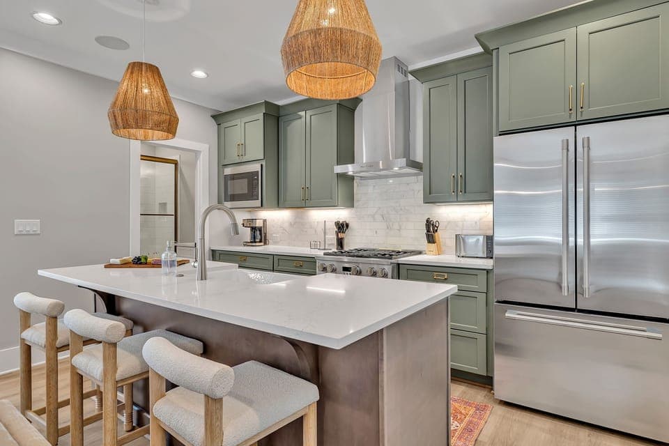 Unit 1 - 2nd Floor: Fully equipped kitchen stocked with all culinary essentials featuring stainless-steel appliances and a kitchen island offering ample counter space and bar seating.