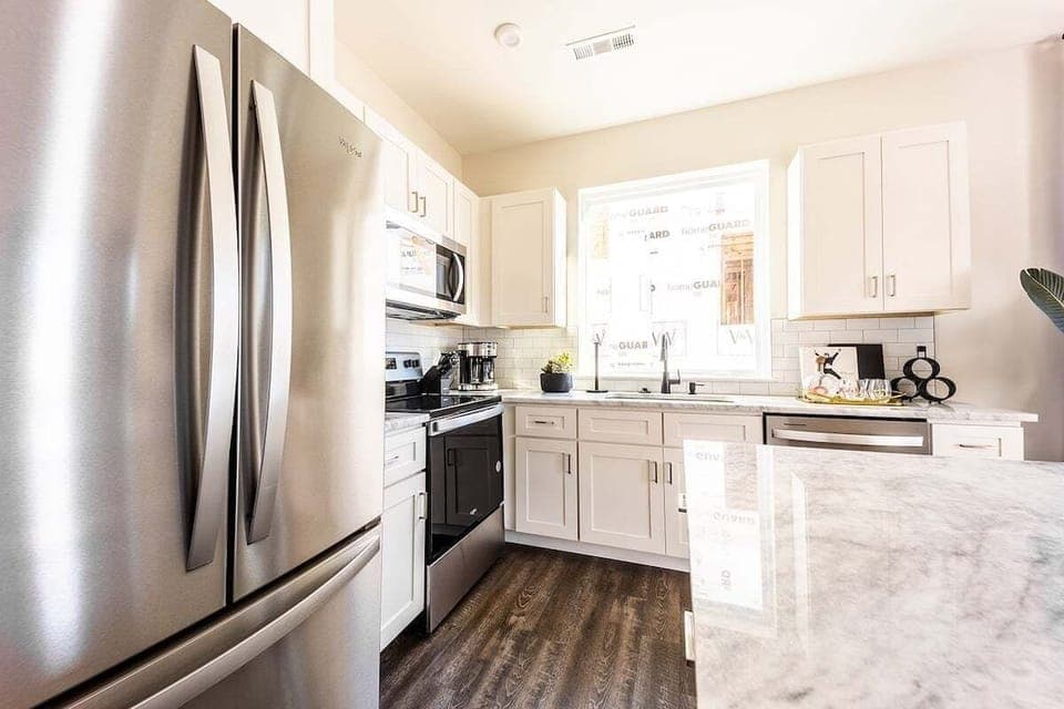 Full kitchen with stainless steel appliances and breakfast bar