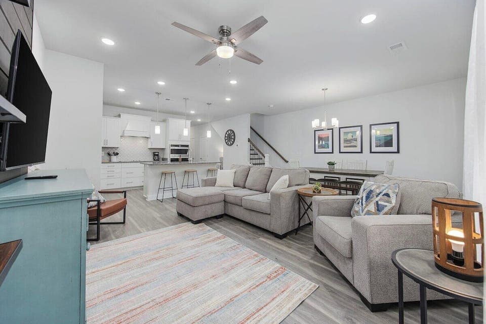 This home features a spacious living area, dining space, modern chefs kitchen, and back patio.