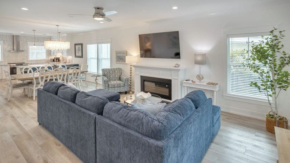 A sleek electric fireplace anchors the room beneath a mounted TV, creating a welcoming gathering spot.