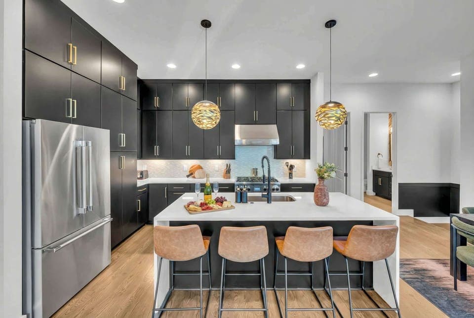 Discover this chic kitchen, perfect for creating memories with friends and family. Ideal for luxury bachelorette parties or corporate retreats, this upscale Nashville rental blends elegance and functionality. Gather around the stunning island and enjoy the inviting ambiance at the heart of your getaway.
