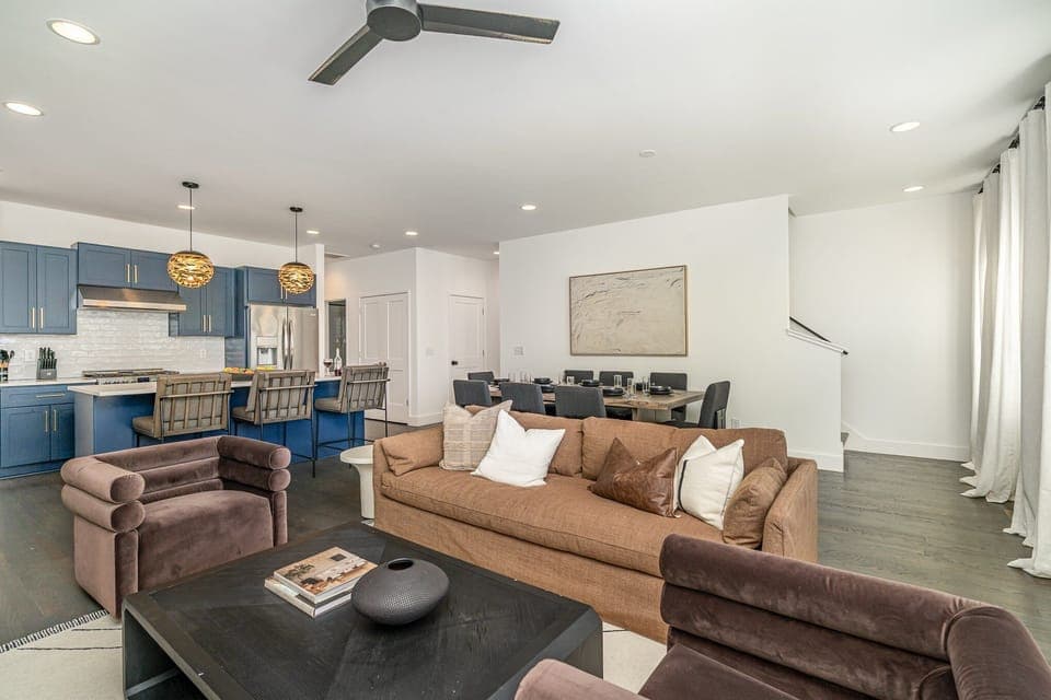 Relax in the cozy and stylish living room, complete with comfortable seating, a flat-screen TV, and large windows that bring in plenty of natural light.