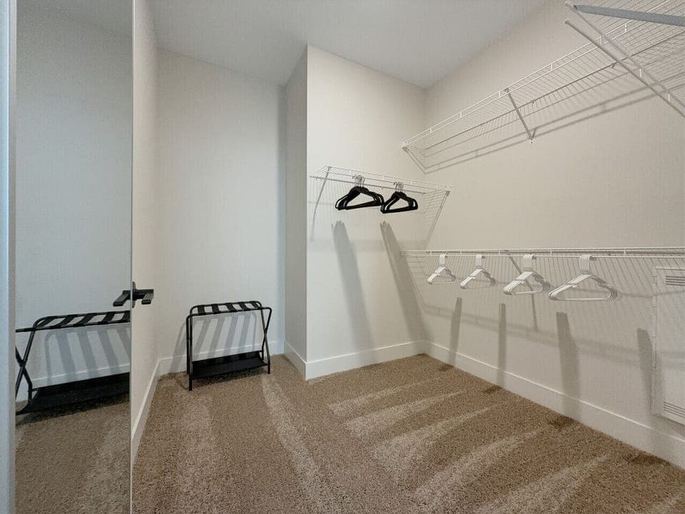 Master Walk-In Closet with Hangers and luggage racks