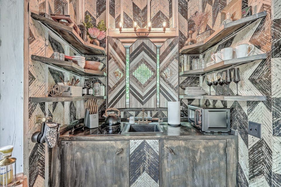 Prepare a meal in our well-stocked kitchen, featuring elegant dark cabinetry and high-end finishes throughout.