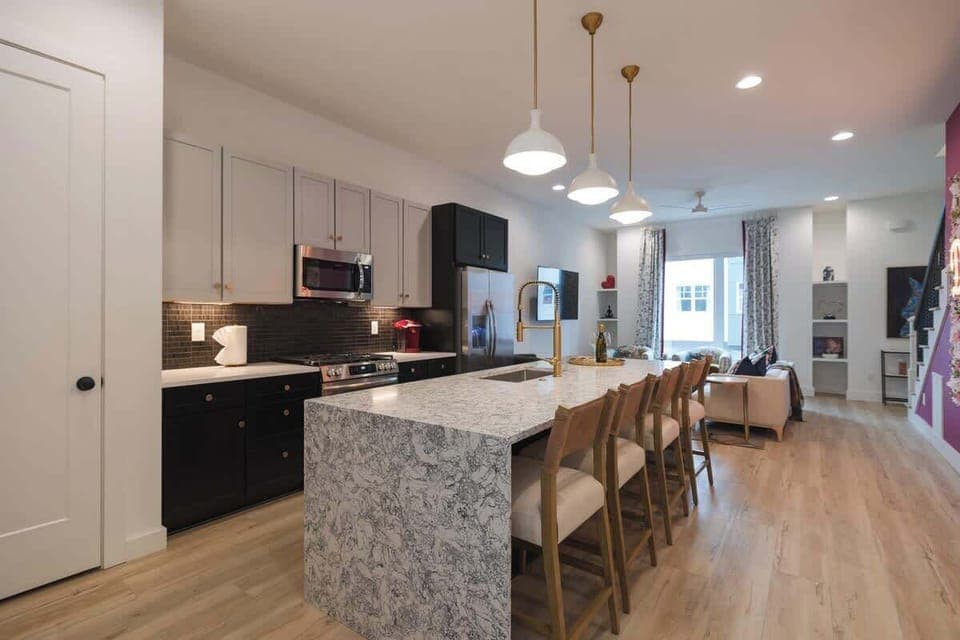 Modern kitchen with a large island and open living area.