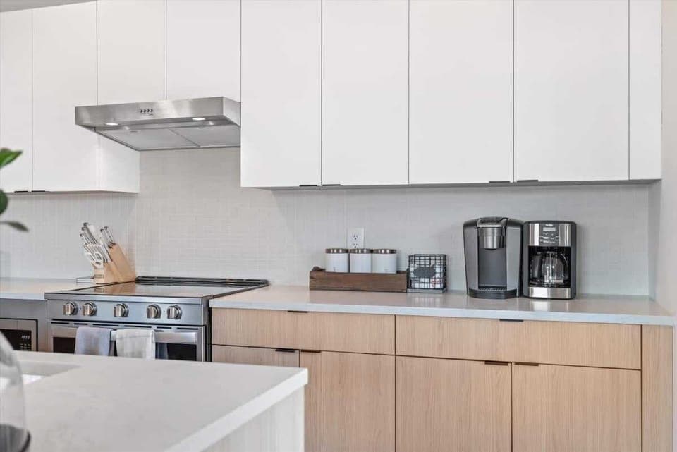 Fully equipped kitchen with white cabinetry and stainless steel appliances