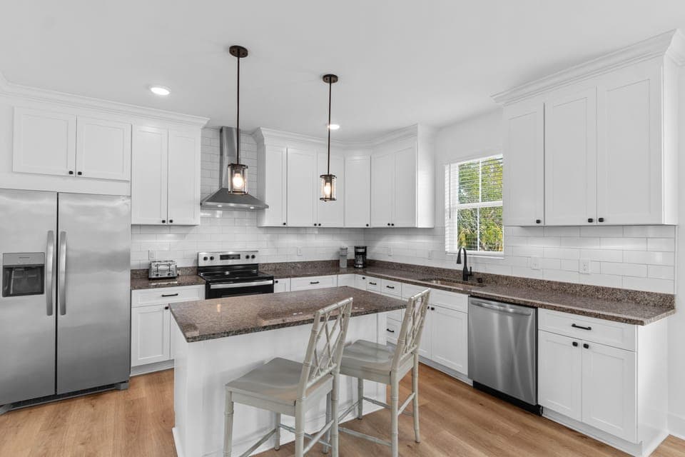 Your spacious kitchen features granite countertops, stainless steel appliances, and a convenient breakfast island where you can enjoy morning coffee.