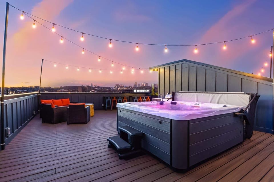 Elevate your Nashville getaway on this stunning rooftop deck with a hot tub, twinkling lights, and panoramic skyline views—perfect for large groups or a chic bachelorette party!