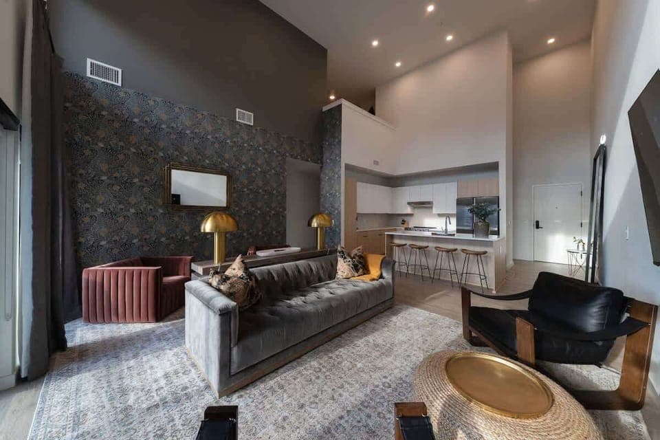 Stunning open-concept living space, tall ceiling and stylish patterned accent wall, and comfortable seating area.