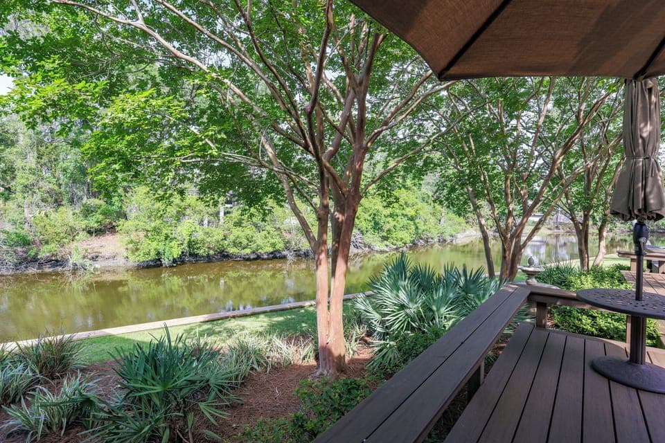This serene outdoor space is designed for slow mornings and shaded afternoons, set along a tranquil lagoon framed by mature trees and lush landscaping.