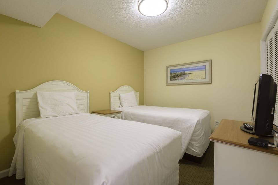 Ideal for kids or extra guests, this cozy twin bedroom features two beds and a charming beach-themed decor.