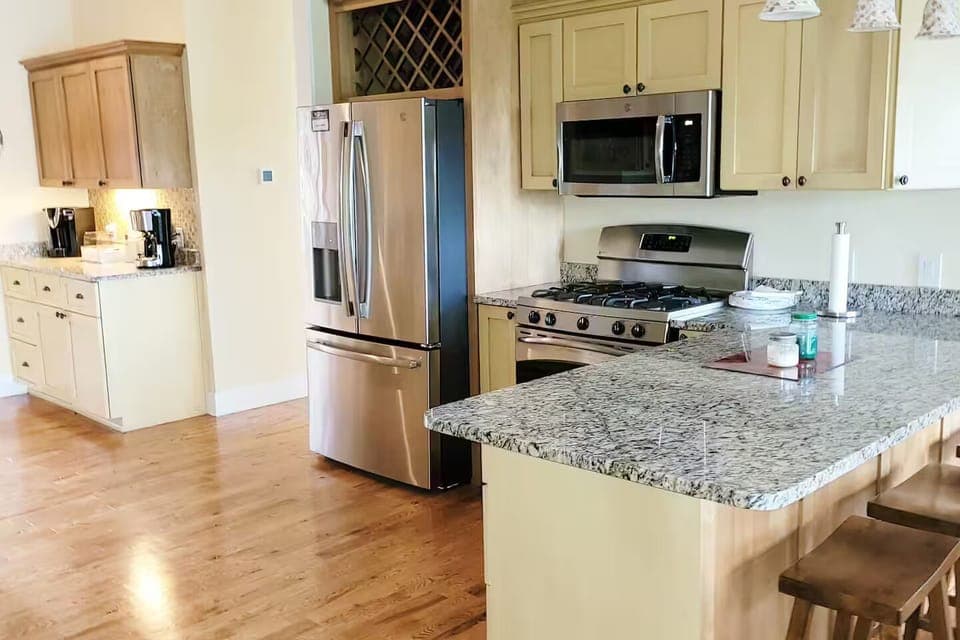 Main house kitchen with gas stove and breakfast bar.