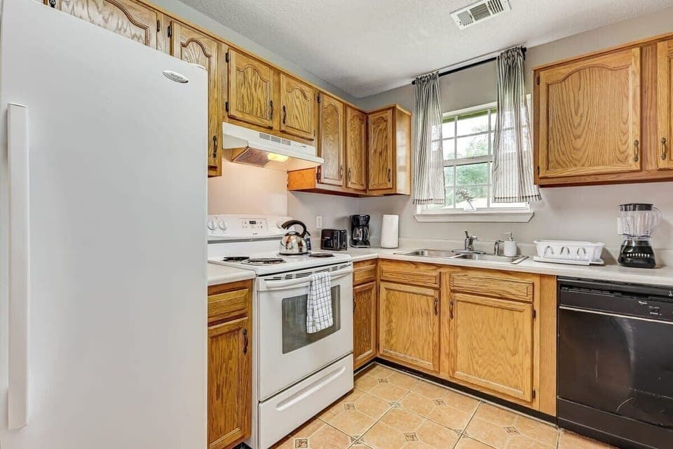 Kitchen with wooden cabinets and essential appliances for preparing everyday meals.