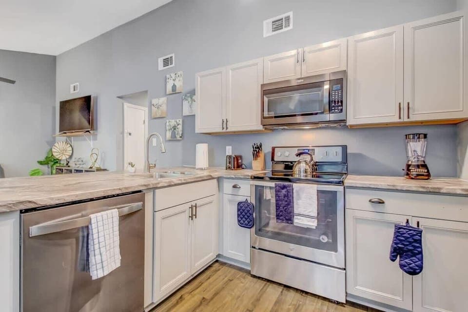 Modern kitchen with white cabinetry, ample countertops, and efficient layout.