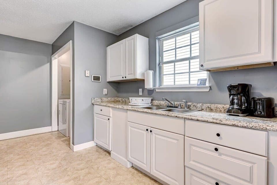 Bright kitchen with white cabinets and ample storage space.