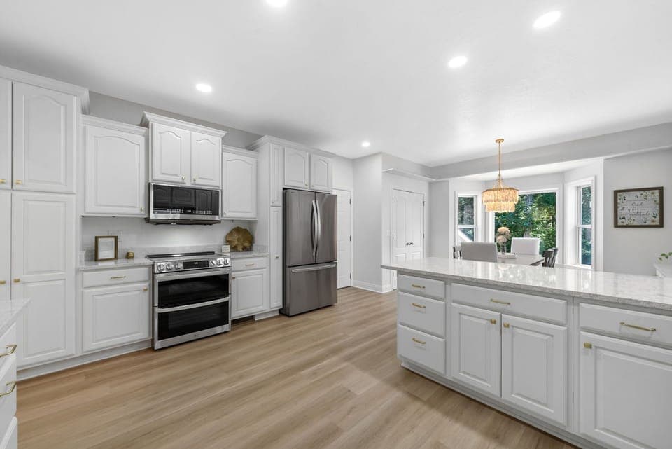Modern all-white kitchen with stainless appliances, perfect for cooking and hosting.
