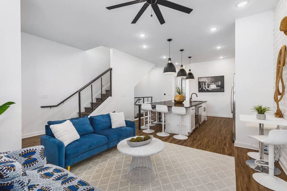 Living room with two comfy couches, a ceiling fan, and a Smart TV with all the streaming apps. Lots of natural light in this home with unique decor highlighting Nashville`s roots in music.