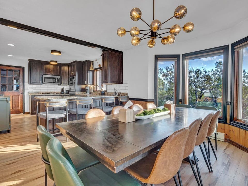 Gather for unforgettable meals at the stylish dining table with panoramic mountain views and an open-concept gourmet kitchen just steps away.