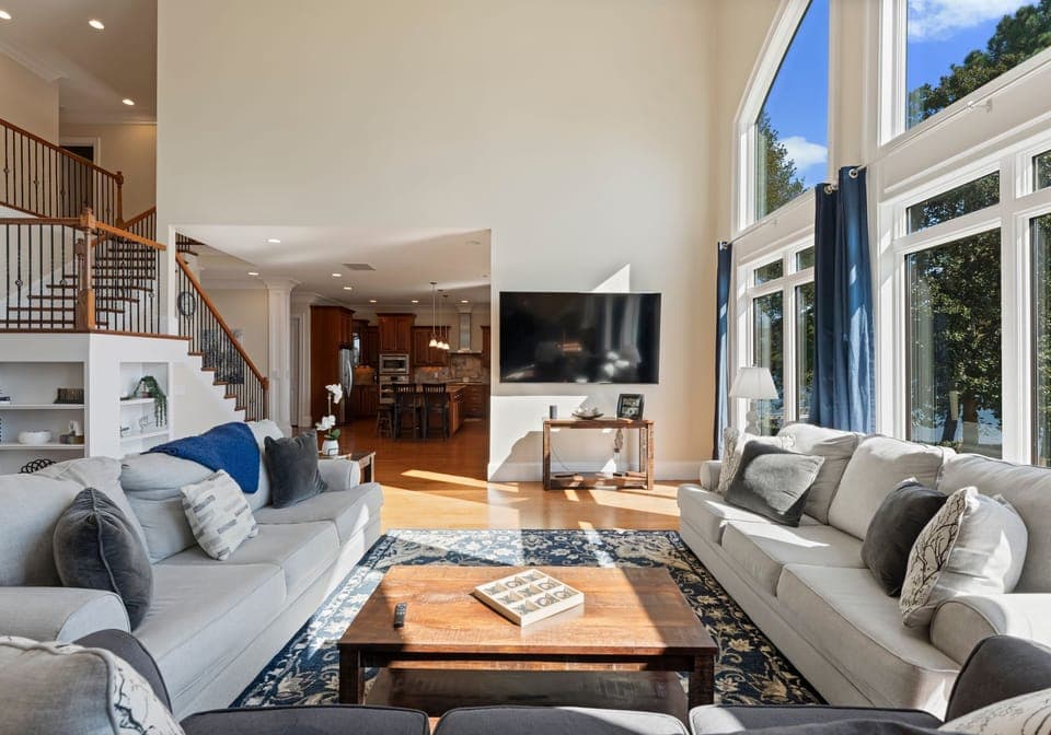 Main sitting area with living room. Three three seater couches, with wall of windows and TV!