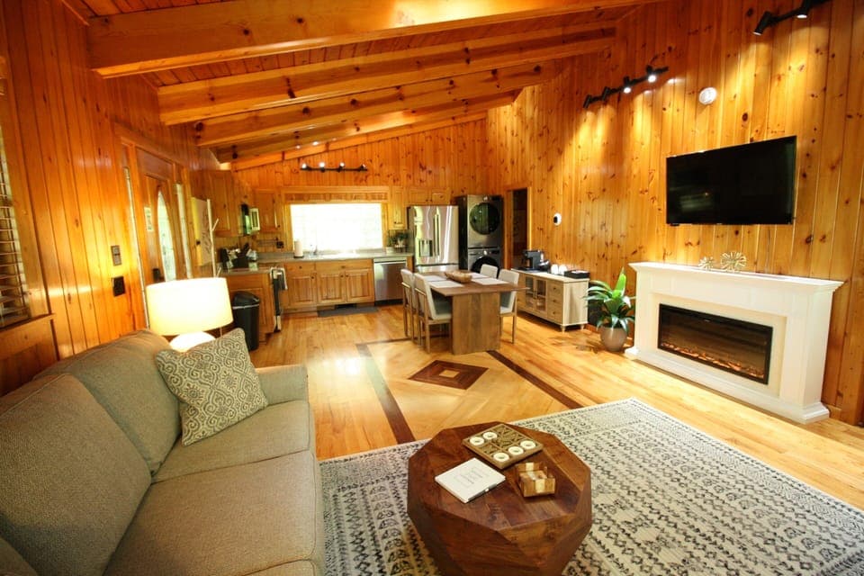 Relax N Unwind by the fireplace with a mounted TV, gather around the dining table for meals, or enjoy the convenience of the modern kitchen—all in one comfortable, thoughtfully designed area.  