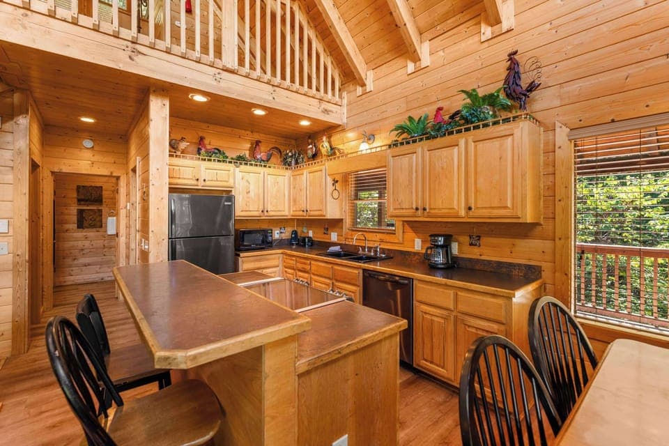 Fully equipped kitchen with stainless steel appliances & bar seating.