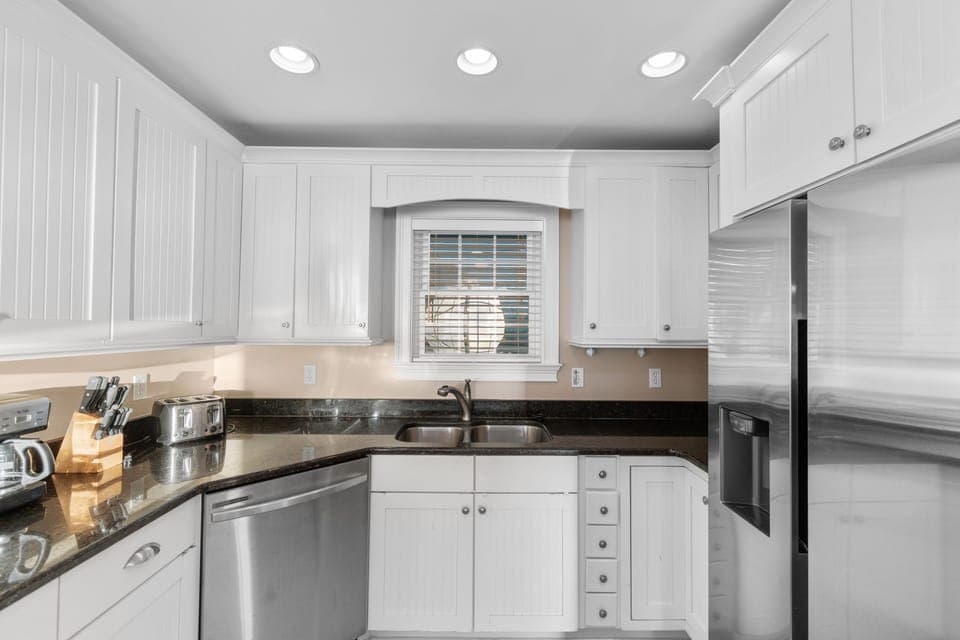 Your fully equipped kitchen features granite countertops, stainless steel appliances, and crisp white cabinetry perfect for preparing memorable meals together.