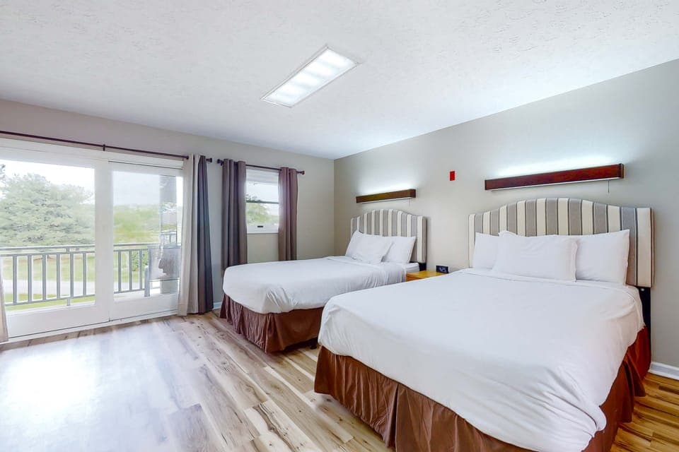 Two queen beds with fresh white bedding and balcony doors. Sleep comfortably on family trips, couples getaways, and weekenders. Bright, clean studio space with spacious room to spread out.