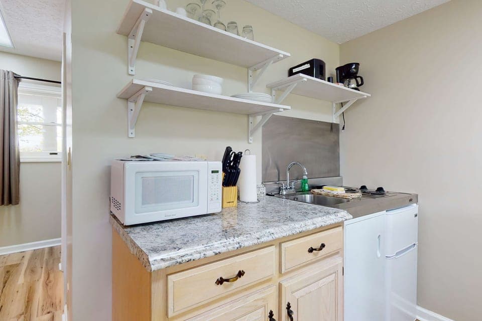 Stocked kitchenette with microwave, mini-fridge, sink, dishes & coffee maker. Easy meals anytime. 