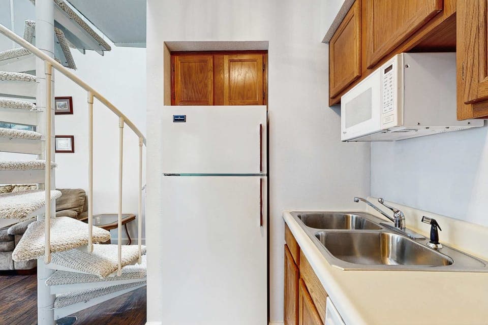 Modern appliances and spiral staircase create a delightful cooking space!
