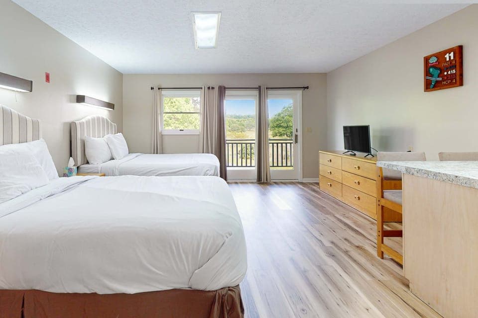 Bright studio with 2 queen beds, crisp linens, smart TV, kitchenette & dining bar; balcony views. Perfect for couples, families, and extended stays. Clean, cozy, convenient studio retreat.