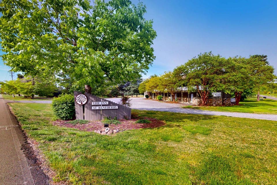 Welcome sign and landscaped grounds at the inn. Easy check-in location near parks, local dining, and attractions; great base for weekend getaway, tournament stays, and extended visits.