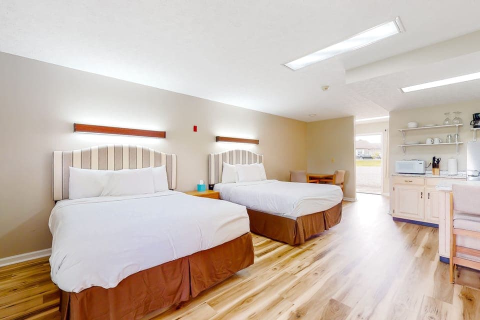 Bright studio suite with 2 queen beds, kitchenette, and dining nook. Ideal for families, groups, and extended stays. Clean, cozy studio lodging with easy access and great value.